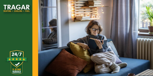 Woman comfortable reading on her couch.